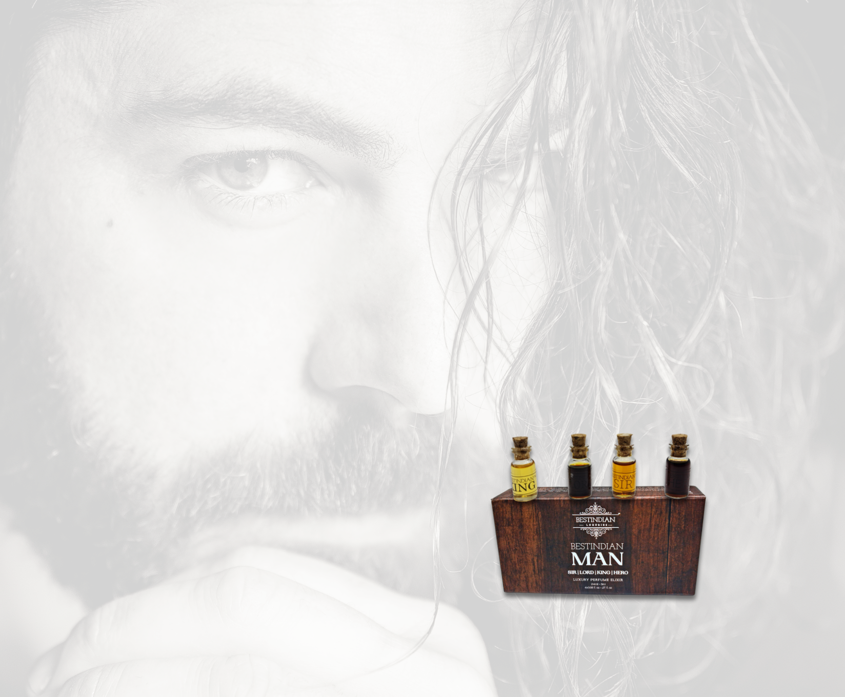 Set of miniature BestIndian Man perfume elixir attar bottles on a wooden packaging box with a long haired man's blurred face in the background
