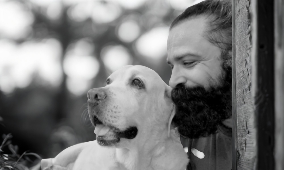A personal black and white photo of Nitin Sahrawat, founder of BestIndian, gently holding his beloved dog Thor.