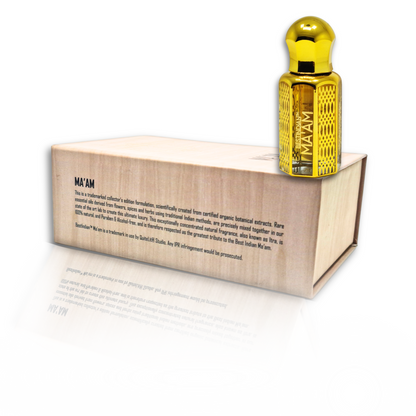 BestIndian™ Ma'am ornate golden bottle positioned on wooden box displaying comprehensive product details, showcasing this premium oud attar for women with saffron and nutmeg notes, crafted as natural alcohol-free perfume oil using traditional Indian methods.